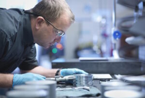 Portrait of engineer measuring engineered part in factory